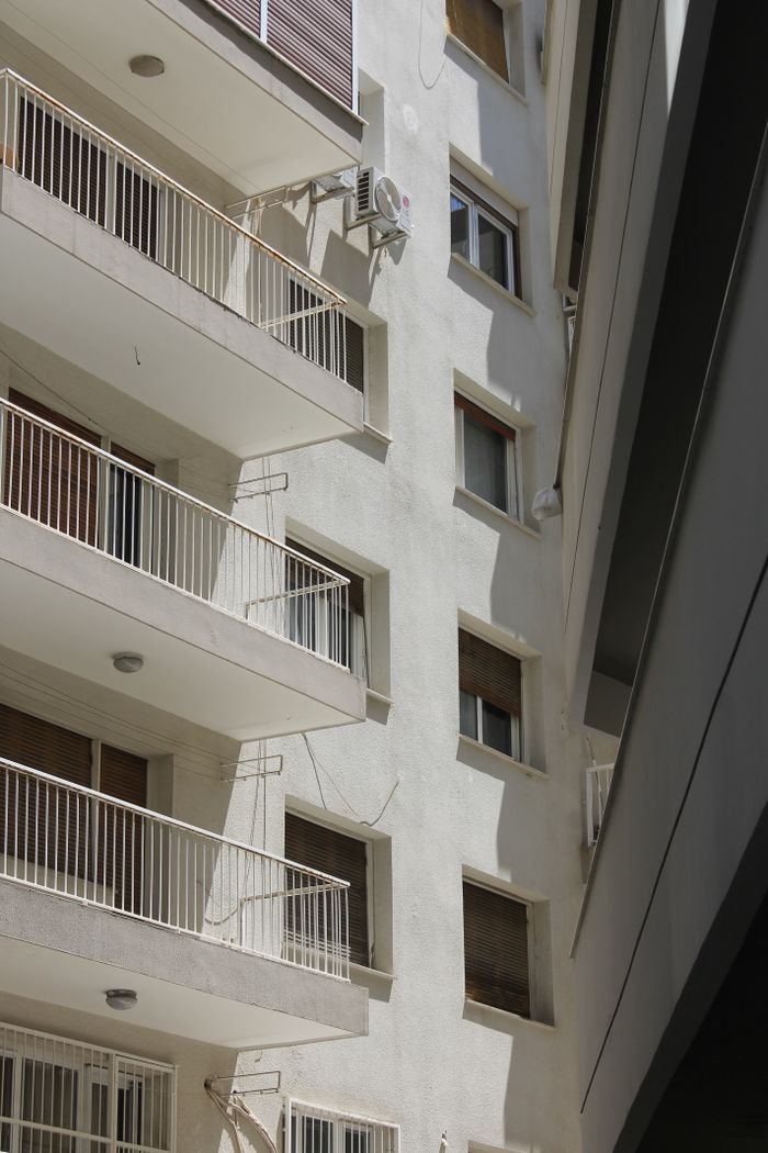 wedding-photography-03 Close-up view of a modern residential building showcasing balconies and windows.